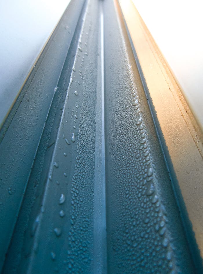 why-choose-us Macro shot of raindrops on a metallic surface, highlighting texture and design.