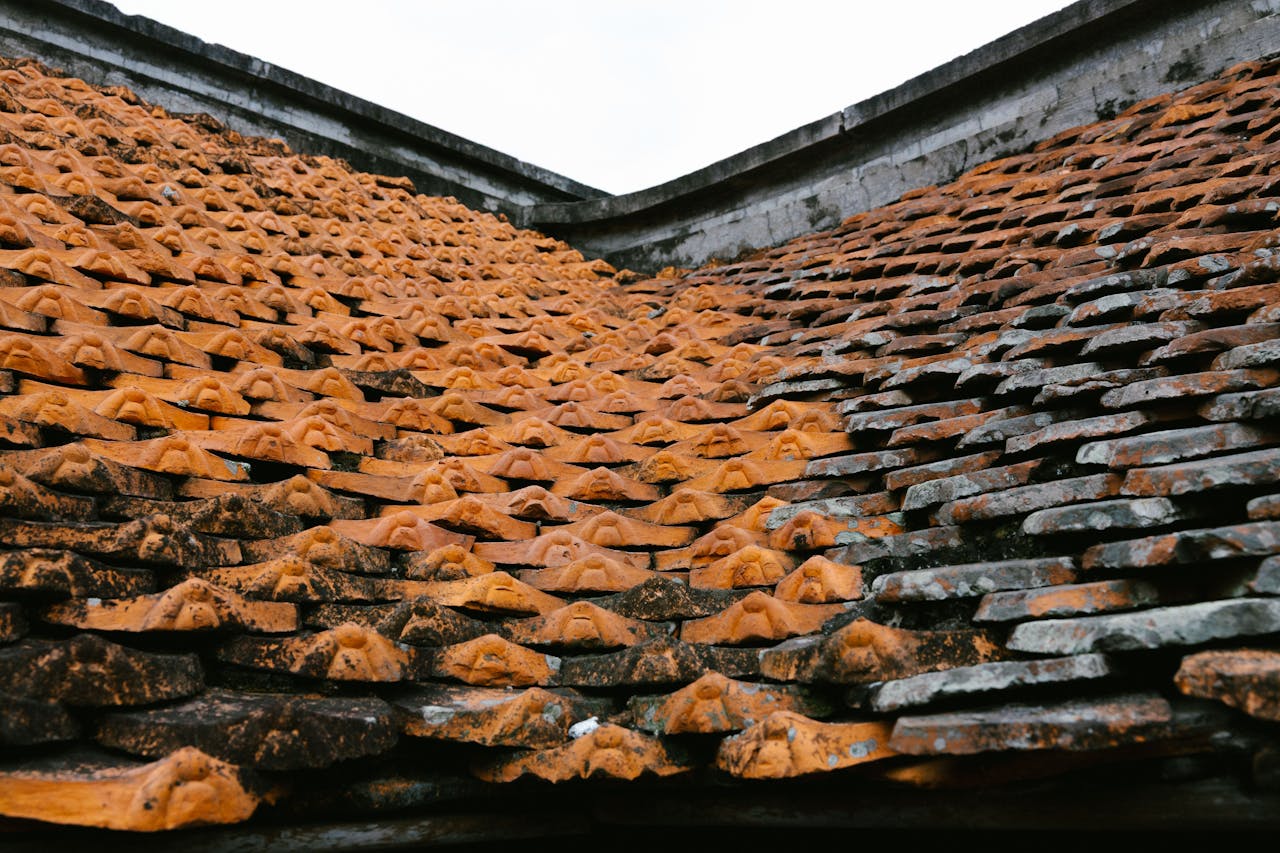get-in-touch Detail of overlapping traditional orange clay roof tiles showing weathering and texture.