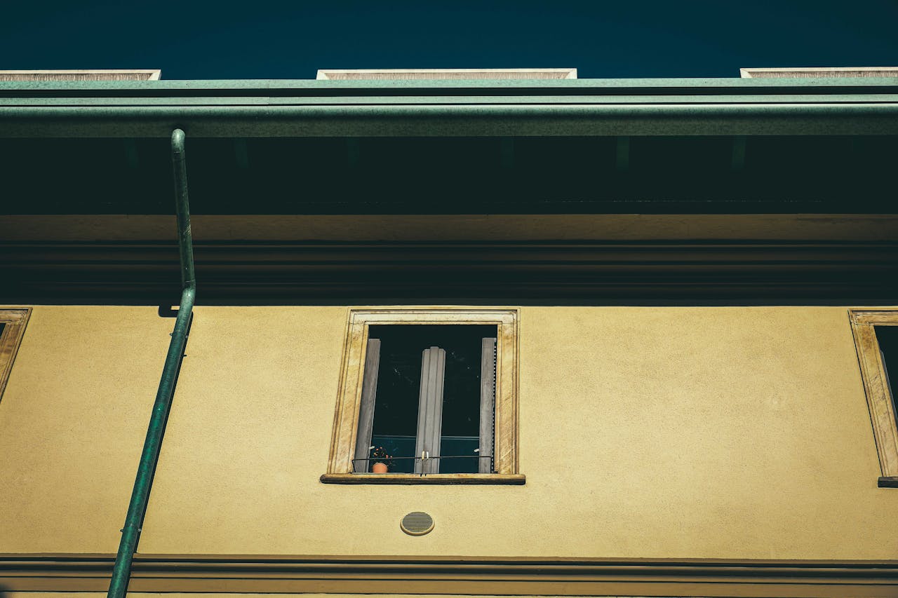 services-06 From below of aged dwelling building exterior with window on front wall in city in sunlight